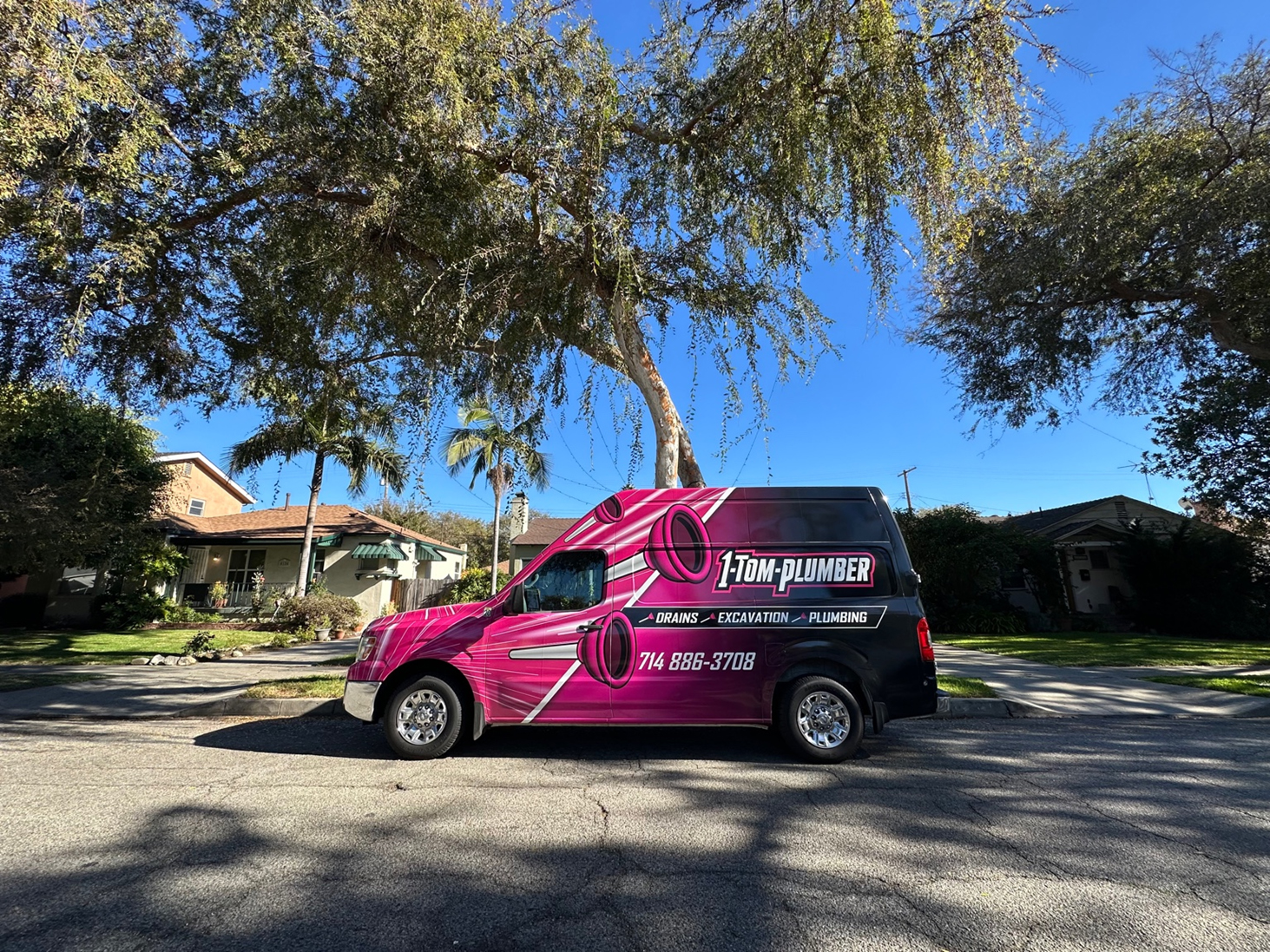 1-Tom-Plumber Anaheim pink service van in front of residential & commercial buildings